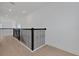 Hallway with wood floors, black metal railings, and bright, recessed lighting at 6608 Quest St, Saint Cloud, FL 34771