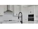 Stylish kitchen with white cabinets, stainless steel appliances, and a modern faucet, designed for functionality at 6608 Quest St, St Cloud, FL 34771