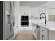 Close-up of kitchen showing stainless steel appliances, white subway tile backsplash, and white kitchen island at 6608 Quest St, Saint Cloud, FL 34771