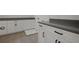Well-lit laundry room with gray countertop, ample storage in white cabinets and gray tile floor at 6608 Quest St, St Cloud, FL 34771