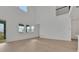 A bright living room featuring luxury vinyl plank flooring, many windows, and tall ceilings at 6608 Quest St, St Cloud, FL 34771