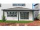 Covered porch featuring green pillars, a sliding glass door, and a small yard at 6608 Quest St, St Cloud, FL 34771
