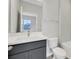 Bathroom features a single vanity with gray cabinets, white countertops, square mirror, and tub with white tile at 6612 Quest St, Saint Cloud, FL 34771