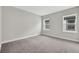 Bedroom showcasing gray carpet, white walls, white trim, and two large windows at 6612 Quest St, St Cloud, FL 34771