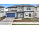 Charming two-story home featuring a blue garage door and trim and a manicured front lawn at 6612 Quest St, St Cloud, FL 34771