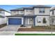 Charming two-story home featuring a blue garage door and trim and a manicured front lawn at 6612 Quest St, St Cloud, FL 34771