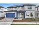 Charming two-story home featuring a blue garage door and trim and a manicured front lawn at 6612 Quest St, St Cloud, FL 34771