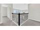 Hallway features gray carpet, white walls, black iron railing with decorative accents, and outside views at 6612 Quest St, St Cloud, FL 34771