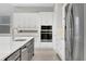 Spacious kitchen with stainless steel appliances, white cabinets, and light countertops at 6612 Quest St, St Cloud, FL 34771