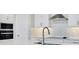 Close-up of a modern kitchen featuring stainless appliances and a sleek white countertop at 6612 Quest St, St Cloud, FL 34771
