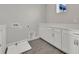 Well-lit laundry room with grey wood-look tile flooring and white cabinets and countertop at 6612 Quest St, St Cloud, FL 34771