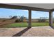 Covered patio area with brick flooring overlooking a serene natural landscape at 6616 Quest St, St Cloud, FL 34771