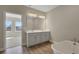 Bright bathroom featuring a double vanity, soaking tub, and tile flooring, creating a stylish retreat at 6616 Quest St, St Cloud, FL 34771