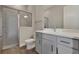Modern bathroom featuring a glass-enclosed shower, gray vanity with white countertop, and wood-look tile flooring at 6616 Quest St, St Cloud, FL 34771