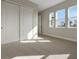 Cozy bedroom with plush carpeting, bright natural light from three windows, and a large closet with sliding doors at 6616 Quest St, St Cloud, FL 34771