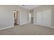 Bedroom features neutral walls, carpet, and dual closets, with a view to ensuite bathroom at 6616 Quest St, St Cloud, FL 34771
