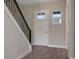 Inviting foyer with sleek staircase, and warm wood-look tile flooring at 6616 Quest St, St Cloud, FL 34771