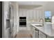Bright kitchen featuring white cabinetry, stainless steel appliances, and an island with a sink and modern faucet at 6616 Quest St, St Cloud, FL 34771