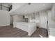 Open concept kitchen with large center island, stainless appliances, and hardwood floors throughout the living space at 6616 Quest St, St Cloud, FL 34771