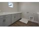 Laundry room featuring gray cabinets, white countertops, and tiled flooring at 6616 Quest St, St Cloud, FL 34771