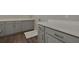 Close up of gray laundry room cabinets with white countertops, and tiled flooring at 6616 Quest St, St Cloud, FL 34771