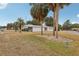 Single story home with palm trees and manicured lawn at 1030 Vermont Ave, Lady Lake, FL 32159