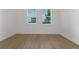 Bright empty bedroom with hardwood floors and natural light from two windows at 15615 Vetta Dr, Montverde, FL 34756