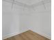 Walk-in closet with metal shelving and wood flooring at 15615 Vetta Dr, Montverde, FL 34756
