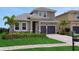 Elegant two-story home with lush lawn, paver driveway, and a two-car garage at 15615 Vetta Dr, Montverde, FL 34756