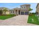 Elegant two-story home with lush lawn, paver driveway, and a two-car garage at 15615 Vetta Dr, Montverde, FL 34756