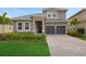 Beautiful two-story home featuring a tile roof, paver driveway, and well-manicured landscaping at 15615 Vetta Dr, Montverde, FL 34756