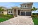 Beautiful two-story home featuring a tile roof, paver driveway, and well-manicured landscaping at 15615 Vetta Dr, Montverde, FL 34756