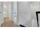 A hallway with white walls, laminate flooring, and doors to bathroom and bedroom at 15615 Vetta Dr, Montverde, FL 34756