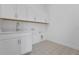 Well-lit laundry room features upper cabinets and attractive tile flooring, adding style and functionality at 15615 Vetta Dr, Montverde, FL 34756
