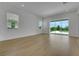 Living room with hardwood floors, bright windows, and sliding glass doors at 15615 Vetta Dr, Montverde, FL 34756