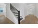 A staircase with white risers and black treads and a black handrail and landing at 15615 Vetta Dr, Montverde, FL 34756