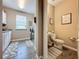 Bright half bathroom with modern fixtures, stylish decor, and convenient access to laundry room at 518 Narrow View Ln, Groveland, FL 34736
