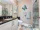 Modern bathroom with a vanity, toilet, decorative butterfly, and a glass-enclosed shower at 518 Narrow View Ln, Groveland, FL 34736