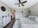 Cozy bedroom with a decorative ceiling fan, a tufted headboard, and a neutral color palette at 518 Narrow View Ln, Groveland, FL 34736