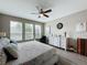 Bright bedroom featuring three windows, a ceiling fan, and a decorative dresser at 518 Narrow View Ln, Groveland, FL 34736