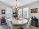 Well-lit dining room featuring a round table, chandelier, and large windows at 518 Narrow View Ln, Groveland, FL 34736
