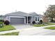 Charming single-story home with a two-car garage, brick driveway, and manicured landscaping at 518 Narrow View Ln, Groveland, FL 34736