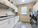 Functional laundry room with modern washer and dryer, ample counter space and storage cabinets at 518 Narrow View Ln, Groveland, FL 34736