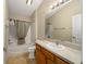 Bathroom with tub shower combo and wood cabinets at 547 Richburg St, The Villages, FL 32162