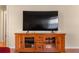 Wood entertainment center with a large flat-screen TV at 547 Richburg St, The Villages, FL 32162