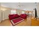 Living room with red couches, wood floors, and a ceiling fan at 547 Richburg St, The Villages, FL 32162