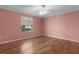 The bedroom features light hardwood floors, neutral paint, large windows, and a ceiling fan at 803 Camino Del Rey Dr, The Villages, FL 32159