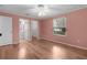 Spacious bedroom with hardwood floors, a ceiling fan, and a view into the en-suite bathroom and walk-in closet at 803 Camino Del Rey Dr, The Villages, FL 32159