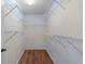 Walk-in closet providing ample storage space with multiple levels of shelving and hardwood floors at 803 Camino Del Rey Dr, The Villages, FL 32159