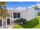 A bright white house featuring a manicured lawn and a lovely pergola near the sunroom at 803 Camino Del Rey Dr, The Villages, FL 32159